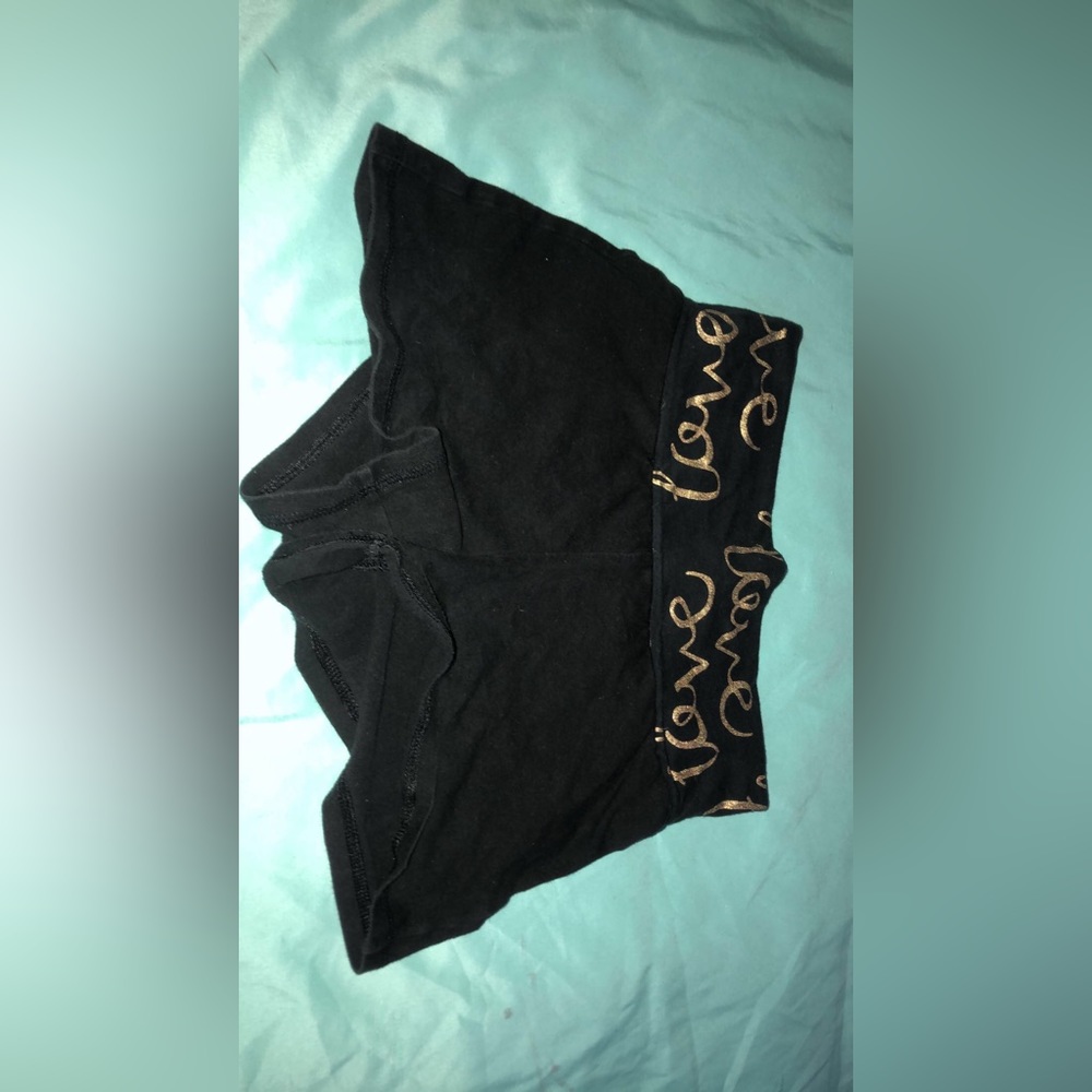 Black shorts with words in gold on the top ends